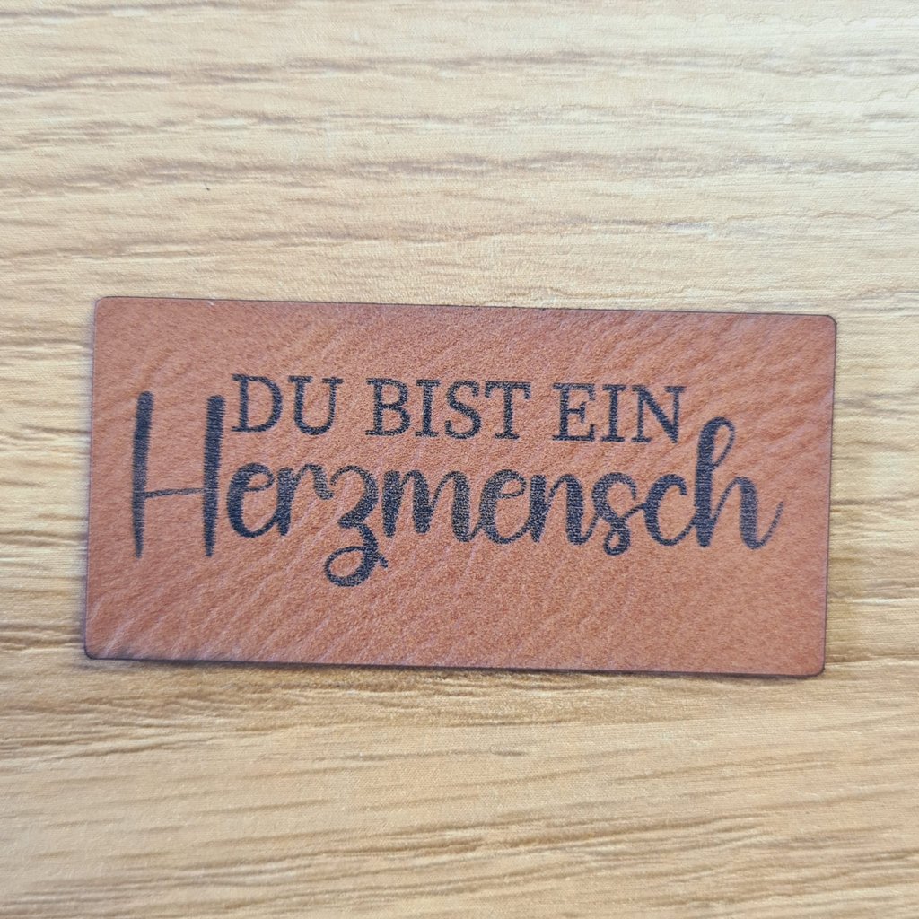 Rechteckiges braunes Kunstleder-Label mit dem Spruch „Du bist ein Herzmensch“, ca. 5 x 2,5 cm, veganes Leder-Patch für Geschenke und Kleidung, laser-graviert bei Schnuckidu
