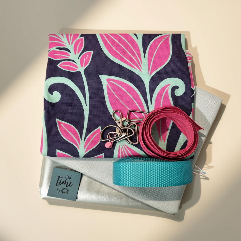 Stoffpaket Taschenpaket Blumen Pink/Mint mit dunkelblauem Canvas mit pink-mintfarbenem Blumenmuster, heller unifarbener Webware, silbernem Kunstleder, mintfarbenem Gurtband, Karabiner-Set, pinkem Reißverschluss und einem "The Time Is Now"-Label.