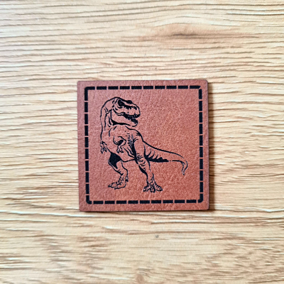 Kunstleder-Label „T-Rex“, 4 x 4 cm, Dino-Patch für Kinderkleidung, vegan, laser-graviert bei Schnuckidu, in Braun oder Schwarz