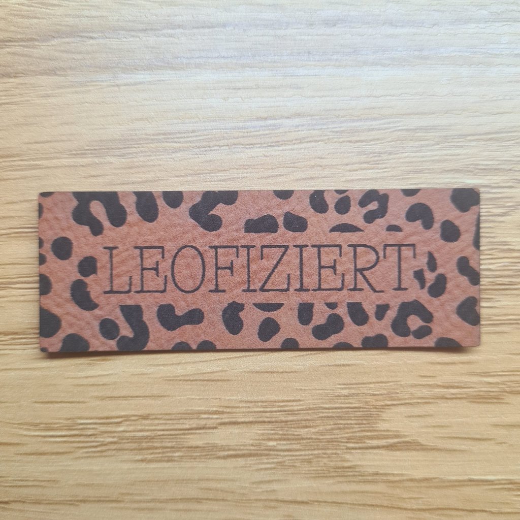 Längliches braunes Kunstleder-Label mit dem Schriftzug „Leofiziert“, ca. 6,8 x 2,5 cm, veganes Leder-Patch für Upcycling und Animal-Print-Projekte, laser-graviert bei Schnuckidu