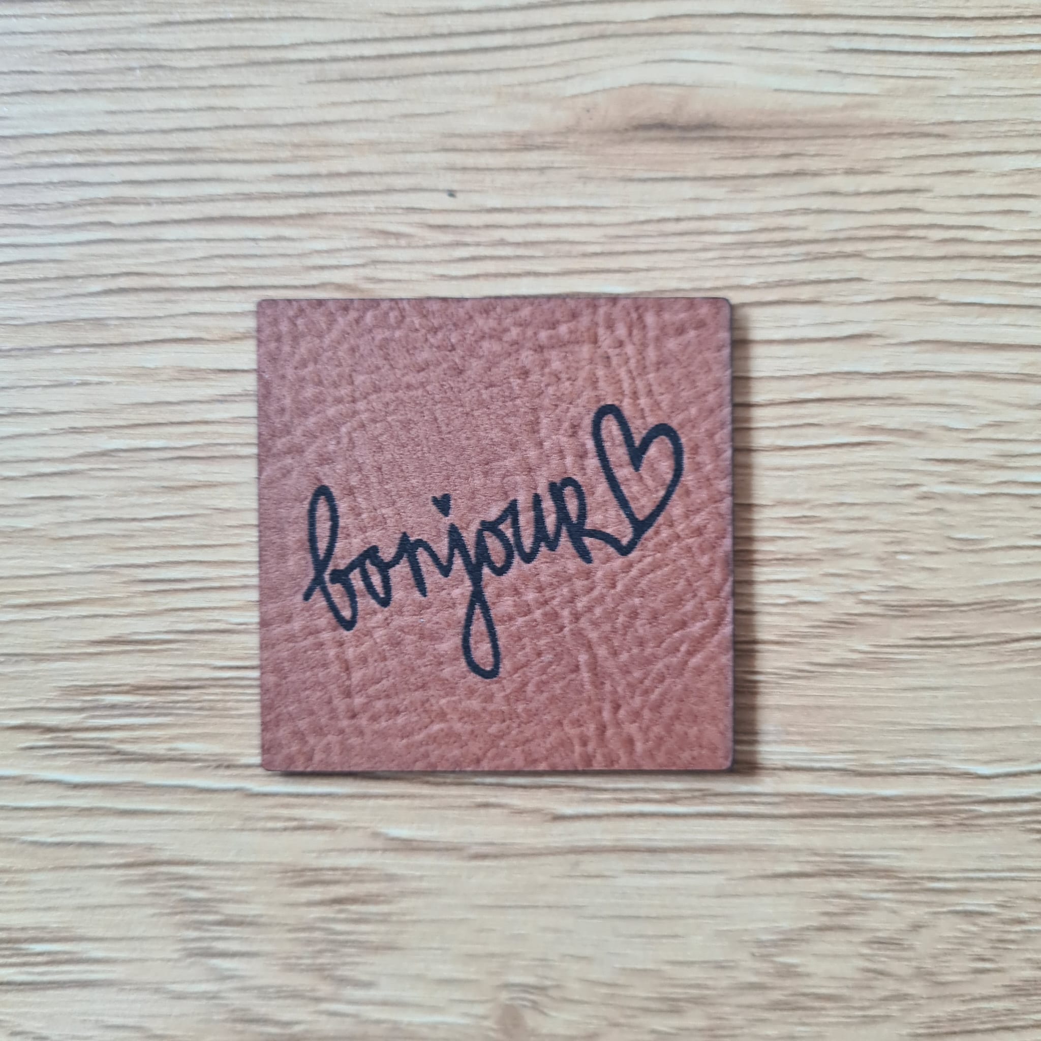 Rechteckiges braunes Kunstleder-Label mit dem Schriftzug „Bonjour“, 5 x 2,4 cm, veganes Nählabel für Kleidung und Accessoires, laser-graviert bei Schnuckidu