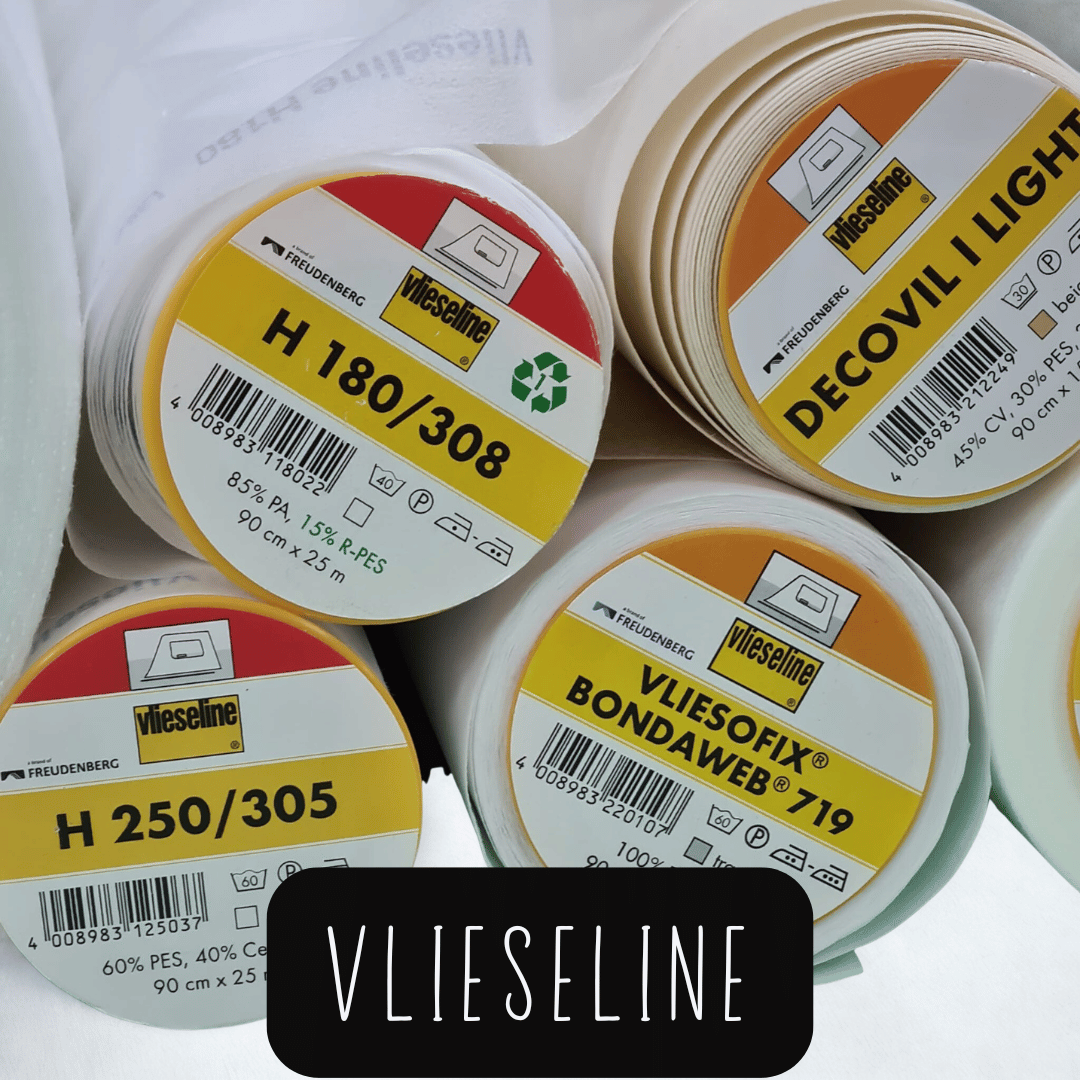 Nahaufnahme von mehreren aufgerollten Vlieseline-Bügelvliesen mit sichtbaren Produktetiketten und Recycling-Symbol