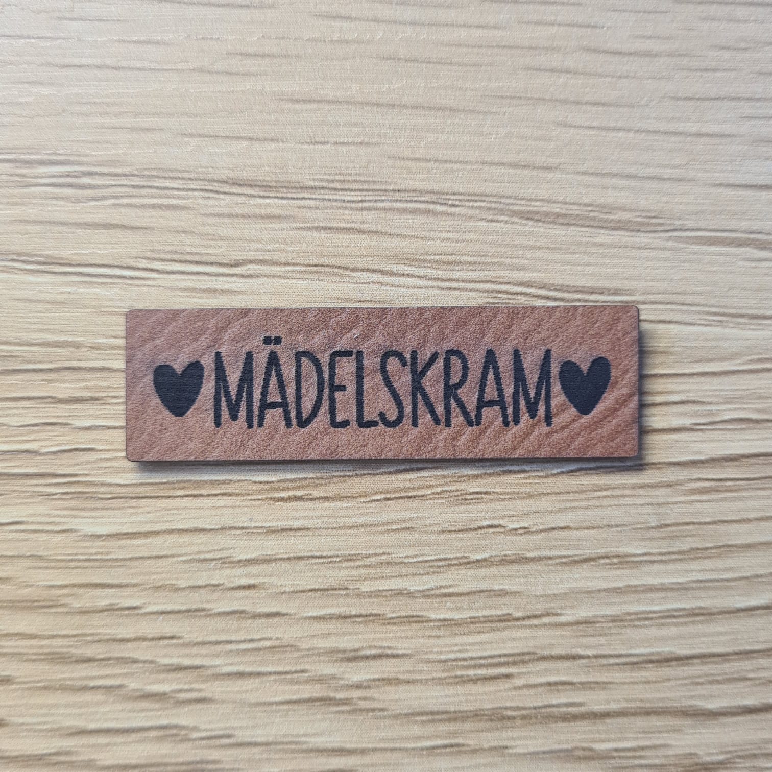 Schnuckidu Kunstleder Nählabel in Braun schmales Querformat mit Schriftzug Mädelskram und zwei eingerahmten Herzen.