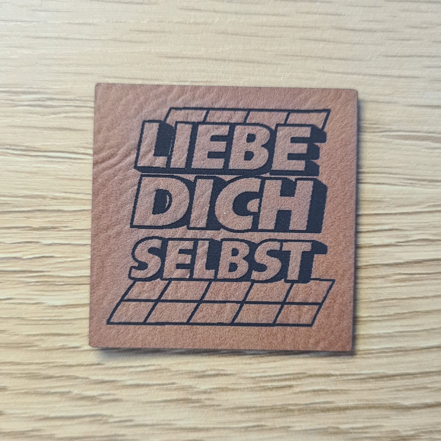 Schnuckidu Kunstleder Nählabel in Braun quadratisch mit dem prägnanten Schriftzug Liebe dich selbst im coolen 3D-Retro-Look.