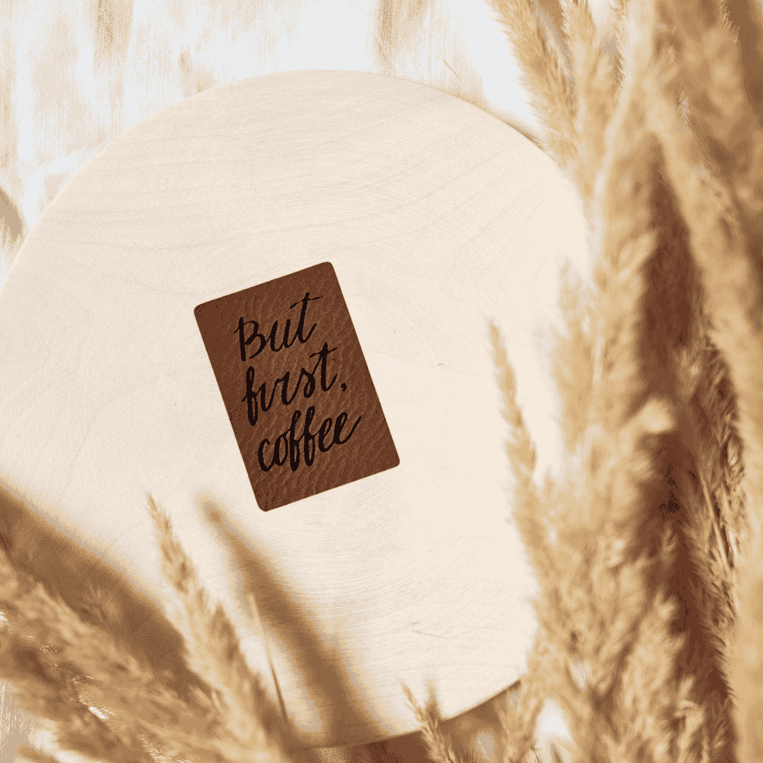 Rechteckiges braunes Kunstleder-Label mit dem Schriftzug „But first Coffee“, 2,4 x 3,5 cm, veganes Nählabel für Kaffeeliebhaber und Lounge-Kleidung, laser-graviert bei Schnuckidu.