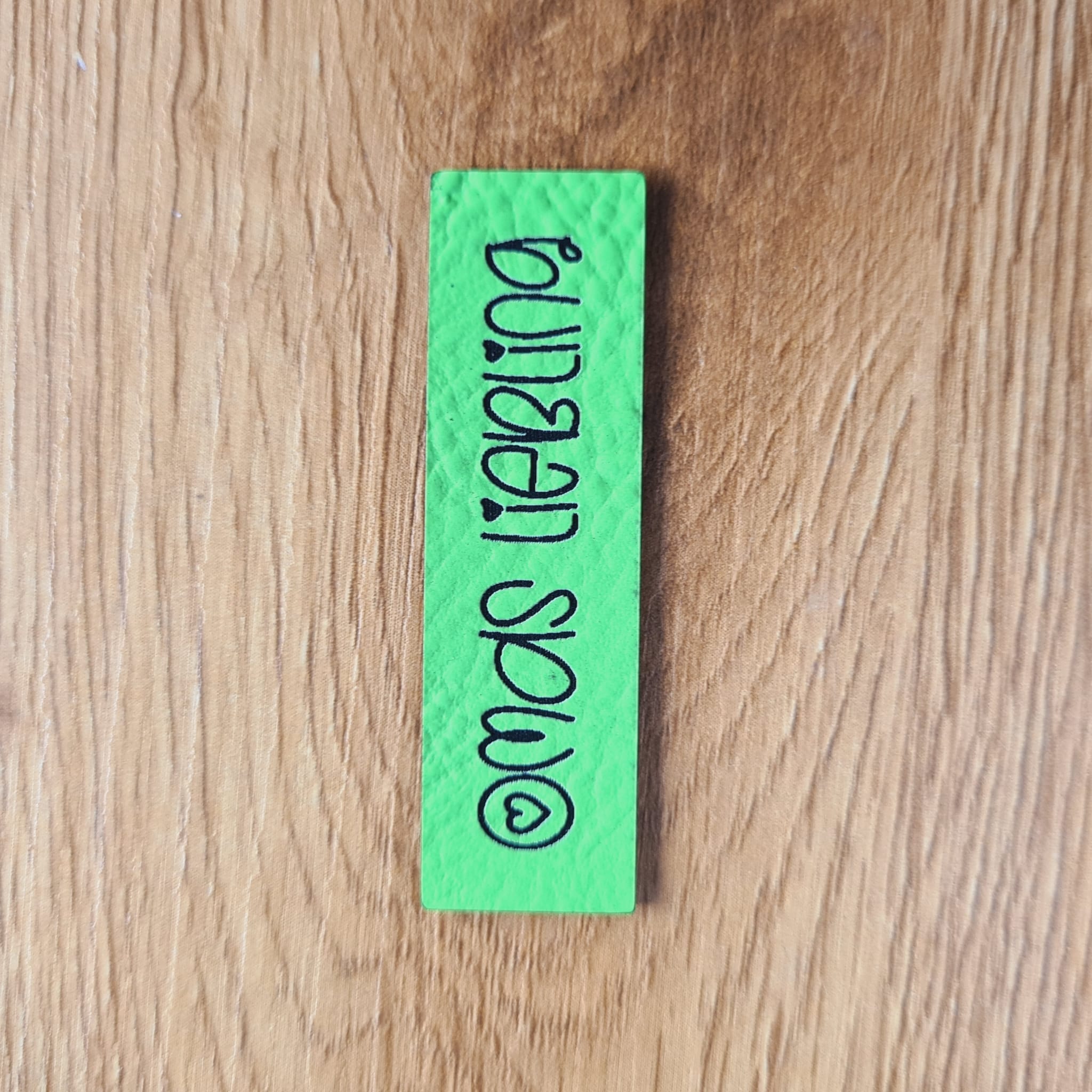 Schmales neon-grünes Kunstleder-Label mit dem Schriftzug „Omas Liebling“, ca. 5 x 1,84 cm, veganes Leder-Patch für Enkelkinder-Kleidung, laser-graviert bei Schnuckidu
