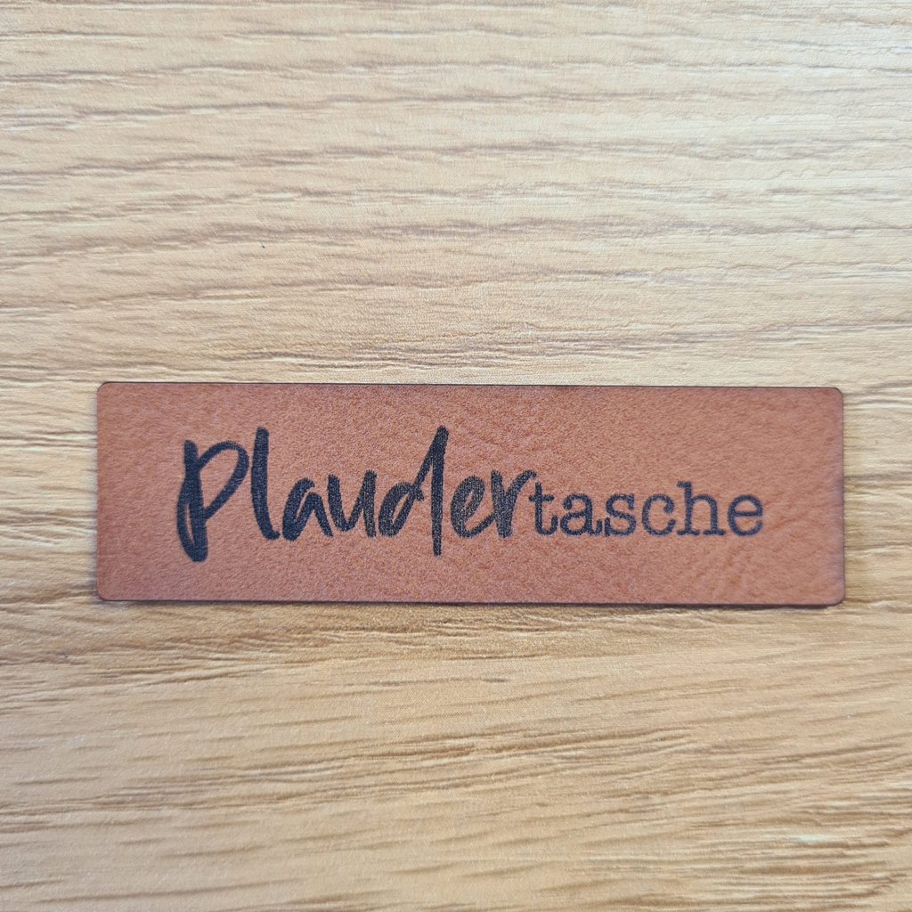 Längliches braunes Kunstleder-Label mit dem Spruch „Plaudertasche“, ca. 6,5 x 2 cm, veganes Leder-Patch für Taschen und Accessoires, laser-graviert bei Schnuckidu.