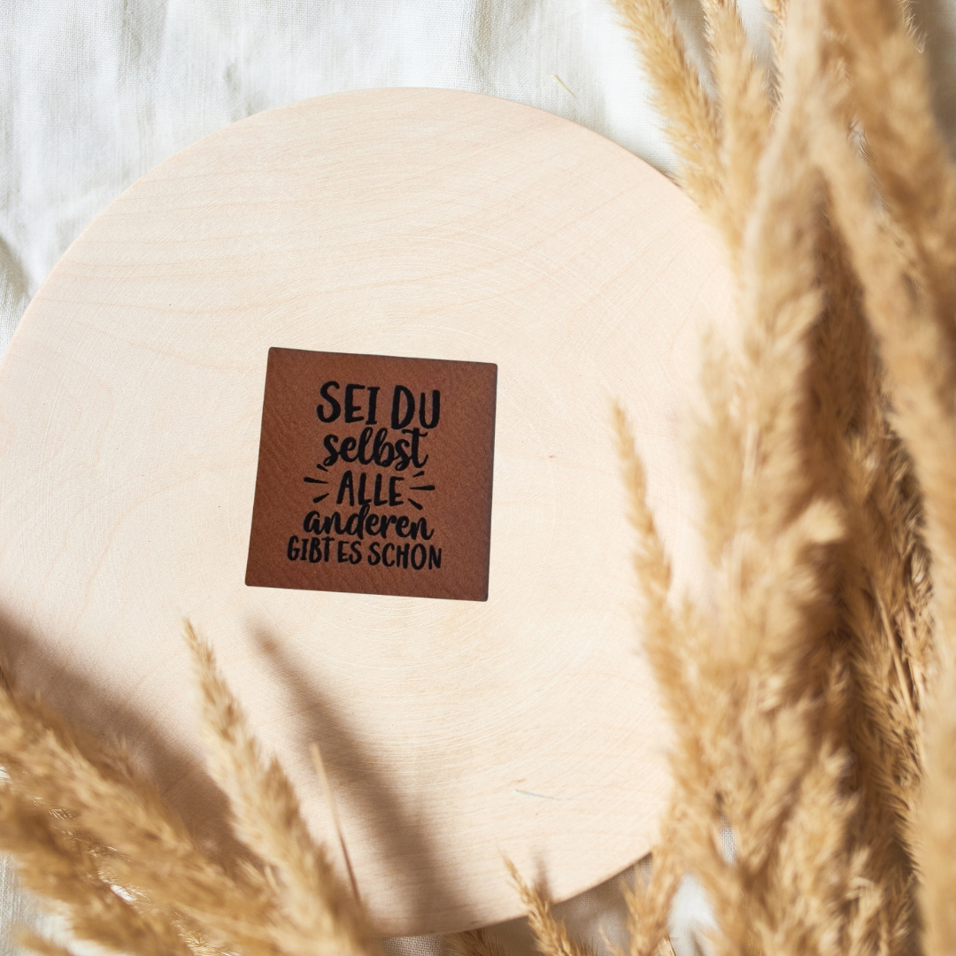 Quadratisches braunes Kunstleder-Label mit dem Spruch „Sei du selbst“, ca. 4 x 4 cm, veganes Leder-Patch für individuelle Nähprojekte, laser-graviert bei Schnuckidu