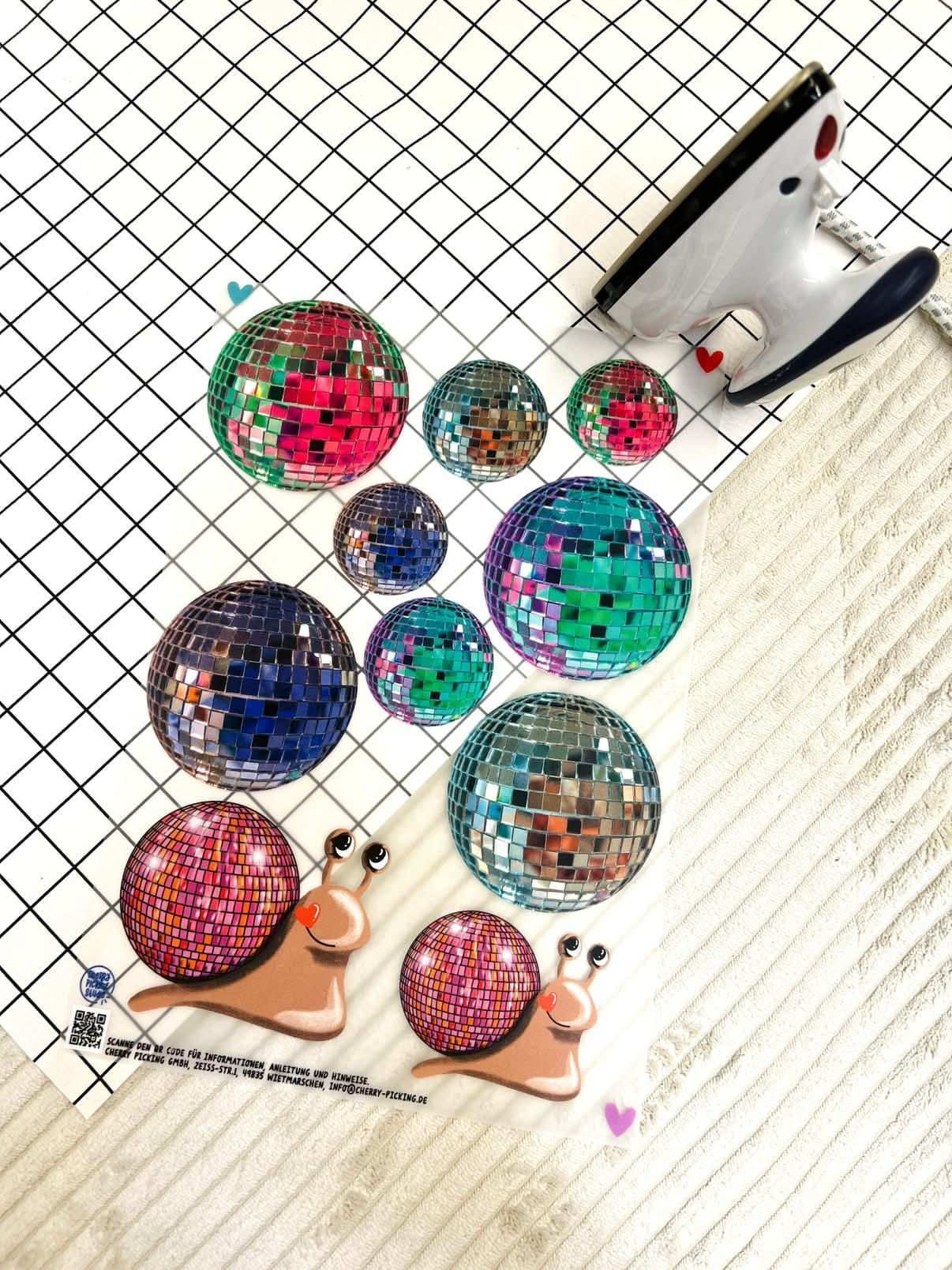 Cherry Picking Bügelbild Bogen Discokugeln und Schnecken mit Discokugel-Schalen auf weißem Cordstoff.