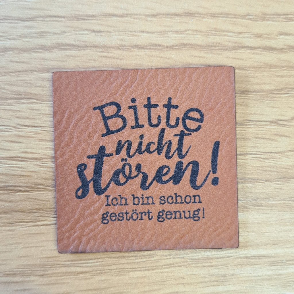 Quadratisches braunes Kunstleder-Label mit dem Spruch „Bitte nicht stören! Ich bin schon gestört genug.“, ca. 4 x 4 cm, veganes Leder-Patch mit Humor, laser-graviert bei Schnuckidu