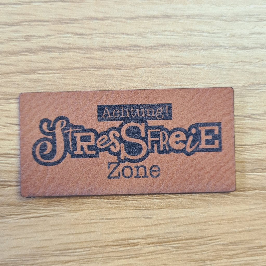 Rechteckiges braunes Kunstleder-Label mit dem Spruch „Achtung - Stressfreie Zone“, ca. 5 x 2,5 cm, veganes Leder-Patch für Home-Deko & Kleidung, laser-graviert bei Schnuckidu