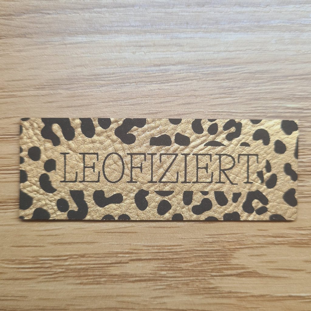 Längliches goldenes Kunstleder-Label mit dem Schriftzug „Leofiziert“, ca. 6,8 x 2,5 cm, veganes Leder-Patch in Metallic-Optik für Animal-Print-Projekte, laser-graviert bei Schnuckidu