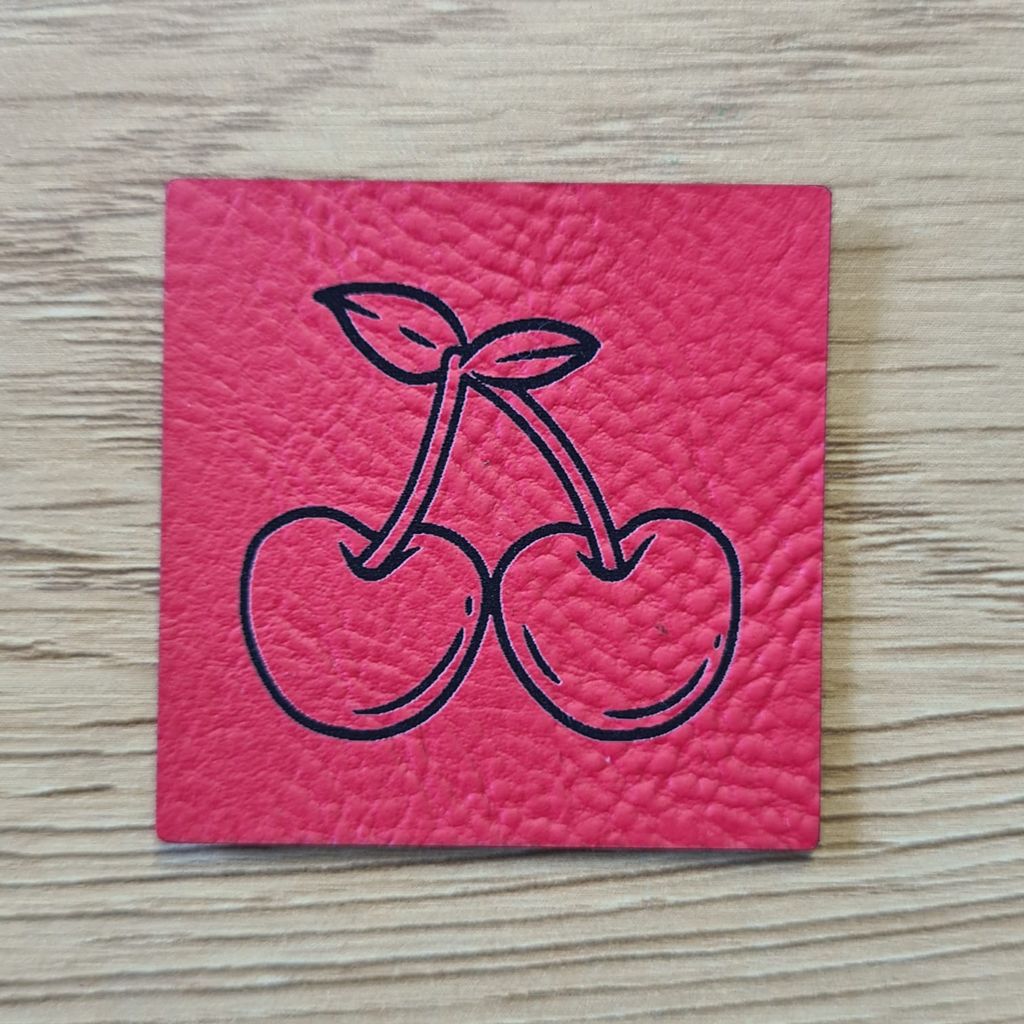 Quadratisches rotes Kunstleder-Label mit einem süßen Kirschen-Motiv, 4 x 4 cm, veganes Nählabel für sommerliche Kinderkleidung und Accessoires, laser-graviert bei Schnuckidu.