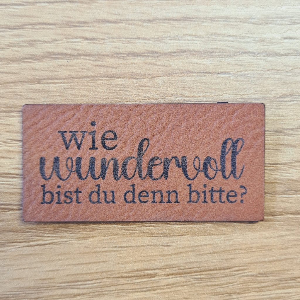 Rechteckiges braunes Kunstleder-Label mit dem Spruch „Wie wundervoll bist du denn bitte?“, ca. 5 x 2,5 cm, veganes Leder-Patch für Komplimente, laser-graviert bei Schnuckidu