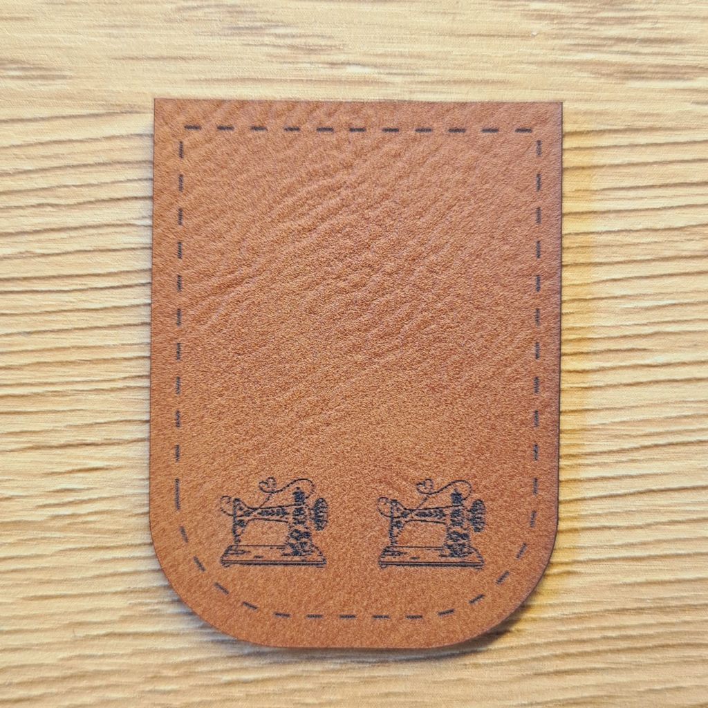 Braunes Kunstleder-Kordelende mit zwei Nähmaschinen-Motiven, U-förmig zum Aufnähen, liebevolles Label für Näh-Fans, vegan, laser-graviert bei Schnuckidu