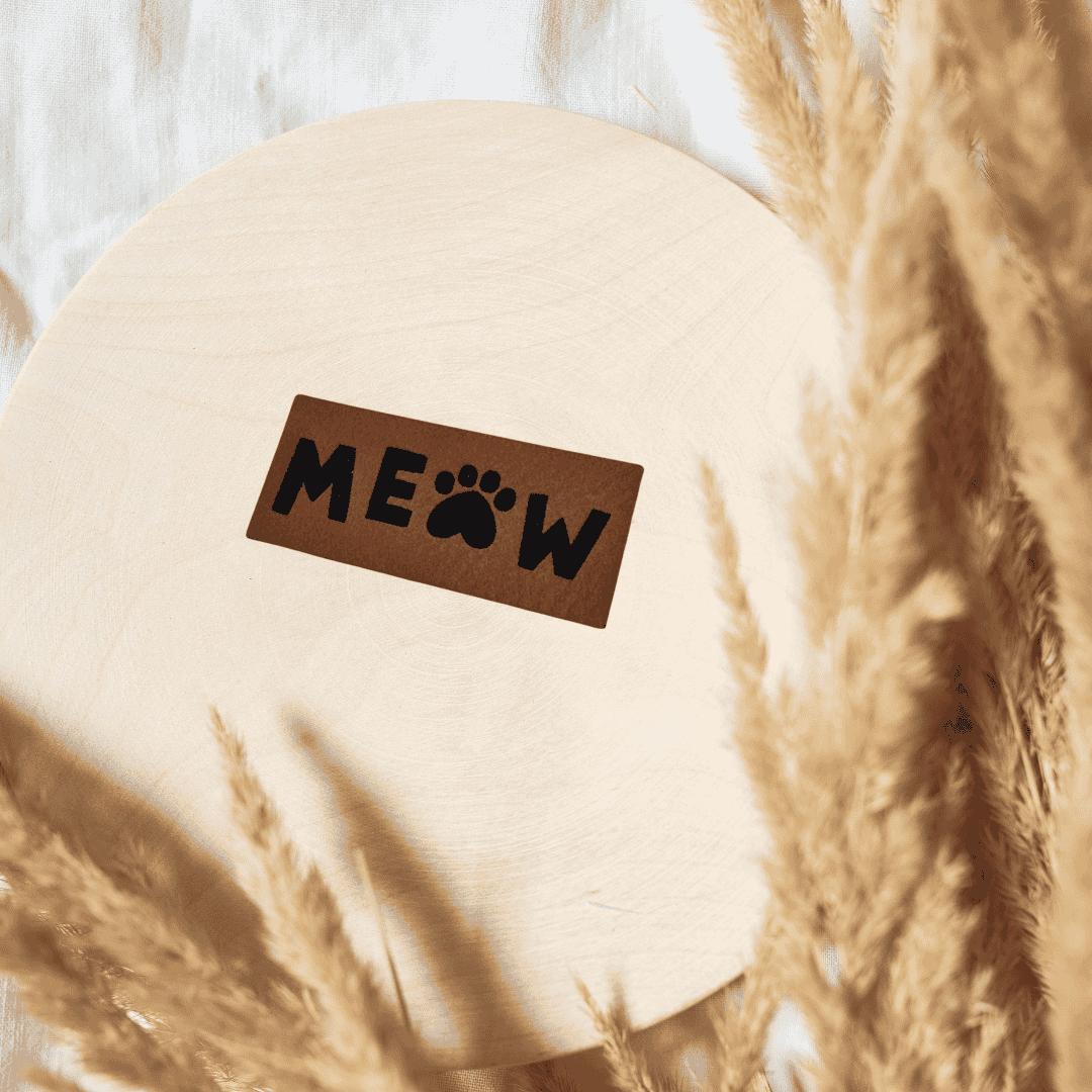 Rechteckiges braunes Kunstleder-Label mit dem Schriftzug „meow“ und einem kleinen Herz, 4 x 2 cm, veganes Nählabel für Katzenfans, laser-graviert bei Schnuckidu.
