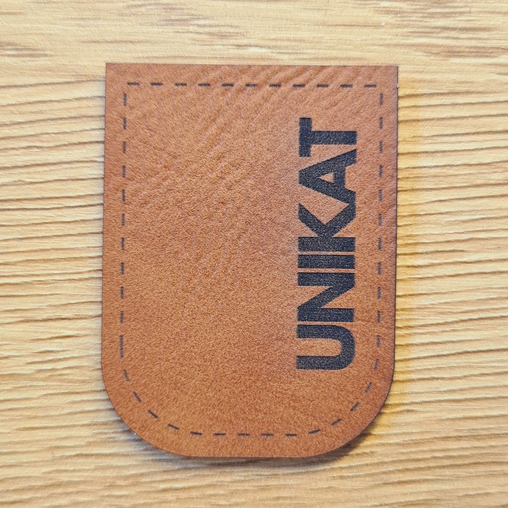 Braunes Kunstleder-Kordelende „UNIKAT“, U-förmig zum Aufnähen, exklusiver Abschluss für handgemachte Unikate, vegan, laser-graviert bei Schnuckidu.