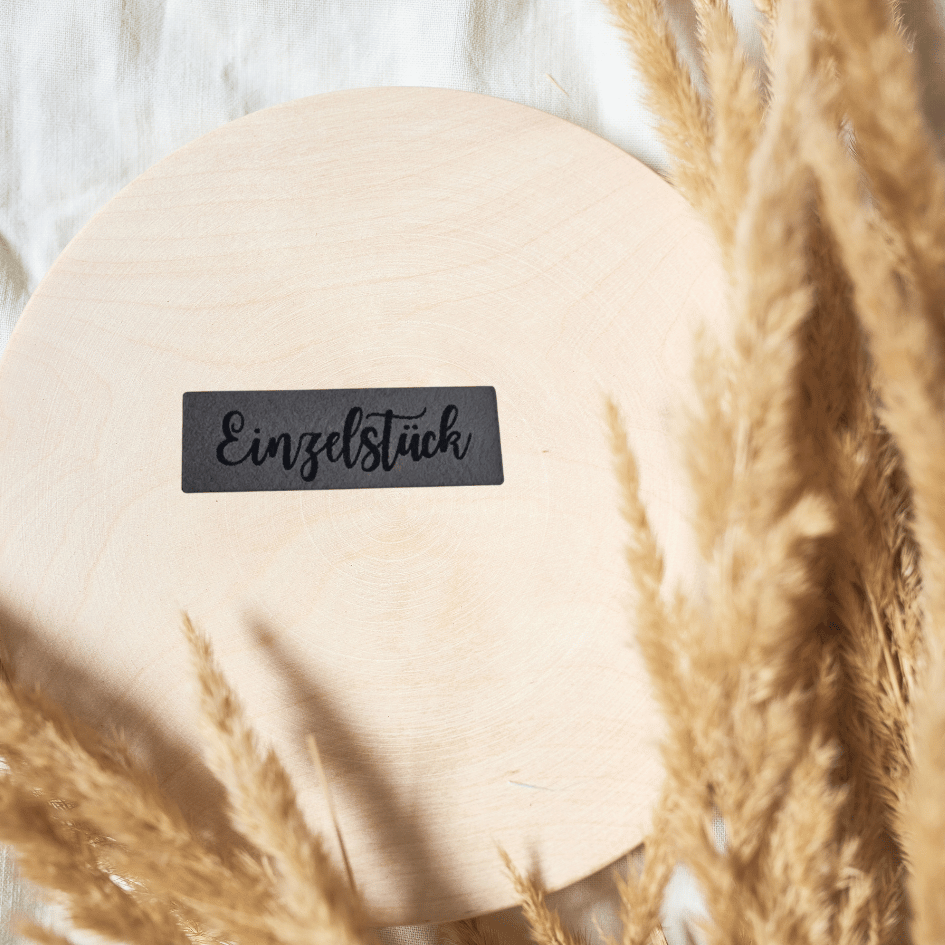 Schmales rechteckiges graues Kunstleder-Label mit dem Schriftzug „Einzelstück“, 4,2 x 1,3 cm, veganes Nählabel für Unikate und Kleidung, laser-graviert bei Schnuckidu.