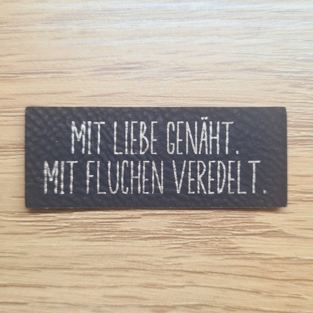 Schwarzes Kunstleder-Label mit goldenem Spruch zum Thema Fluchen, ca. 5,8 x 2,2 cm, veganes Leder-Patch mit Humor, laser-graviert bei Schnuckidu