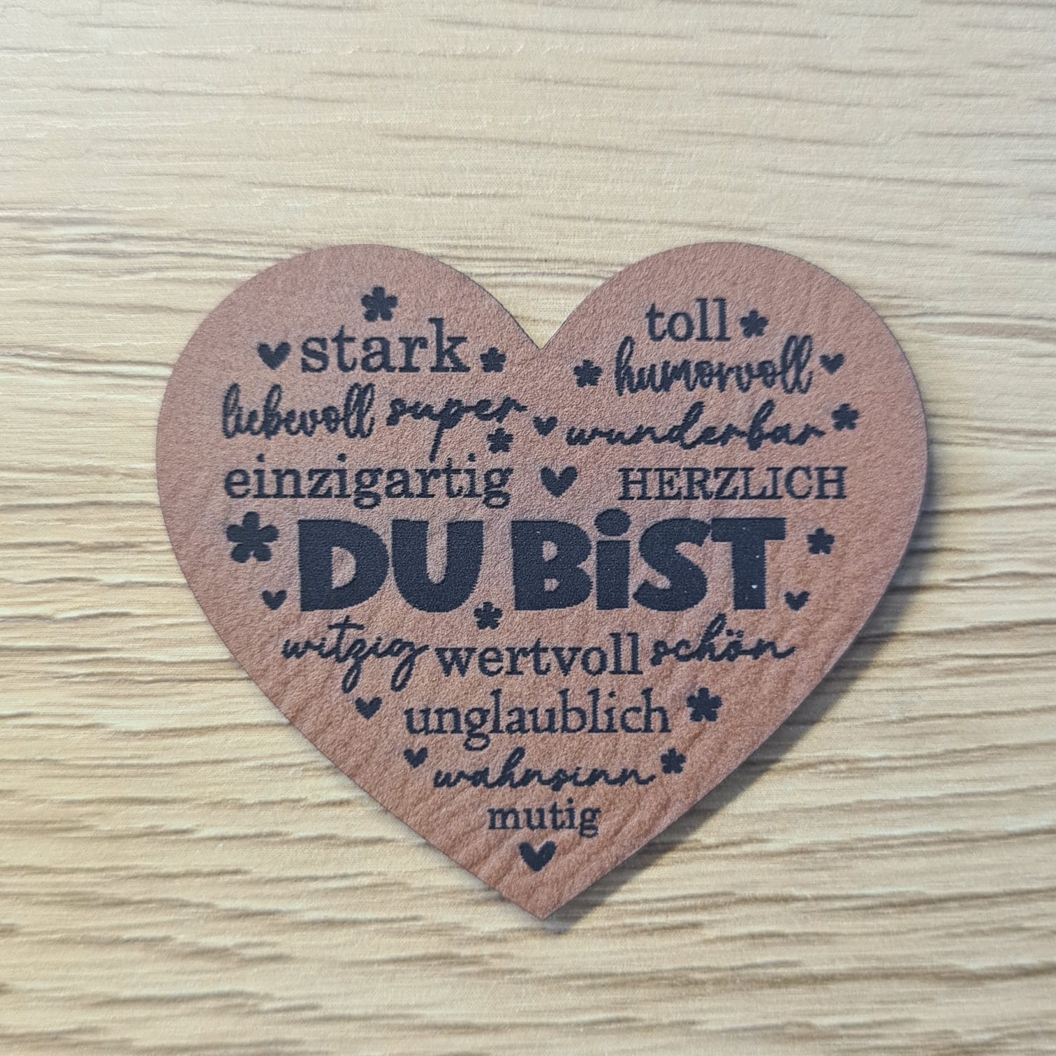 Schnuckidu Kunstleder Nählabel in Braun Herzform mit der Aufschrift Du bist und vielen positiven Eigenschaften wie stark, einzigartig und mutig.