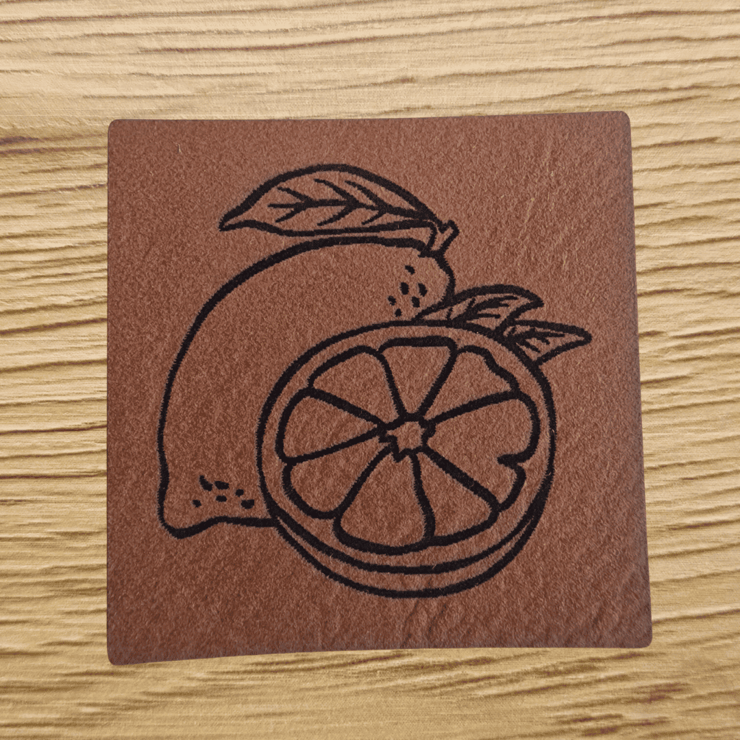 Quadratisches braunes Kunstleder-Label mit einer gravierten Zitrone, 4,0 x 4,0 cm, veganes Nählabel für Kleidung und Küchenaccessoires, laser-graviert bei Schnuckidu.