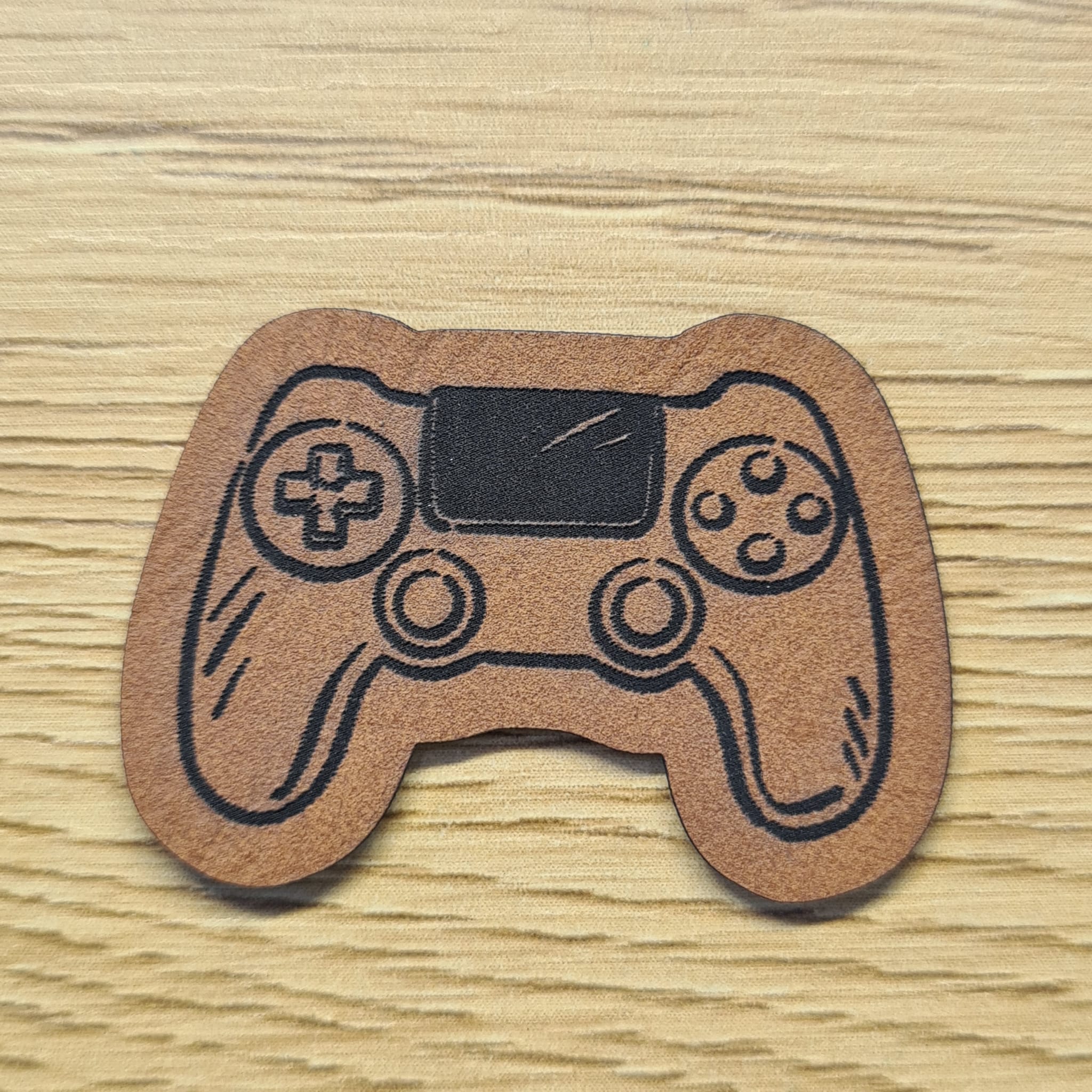 Kunstleder-Label „Controller“, 4 x 2,8 cm, Freiform, Gaming-Motiv für Hoodies und Taschen, vegan, laser-graviert bei Schnuckidu, in Braun.