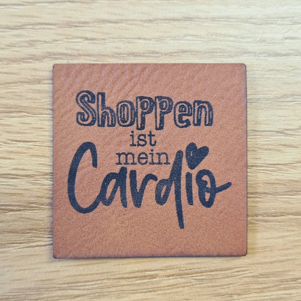 Quadratisches braunes Kunstleder-Label mit dem Spruch „Shoppen ist mein Cardio“, ca. 4 x 4 cm, veganes Leder-Patch für Mode-Begeisterte, laser-graviert bei Schnuckidu