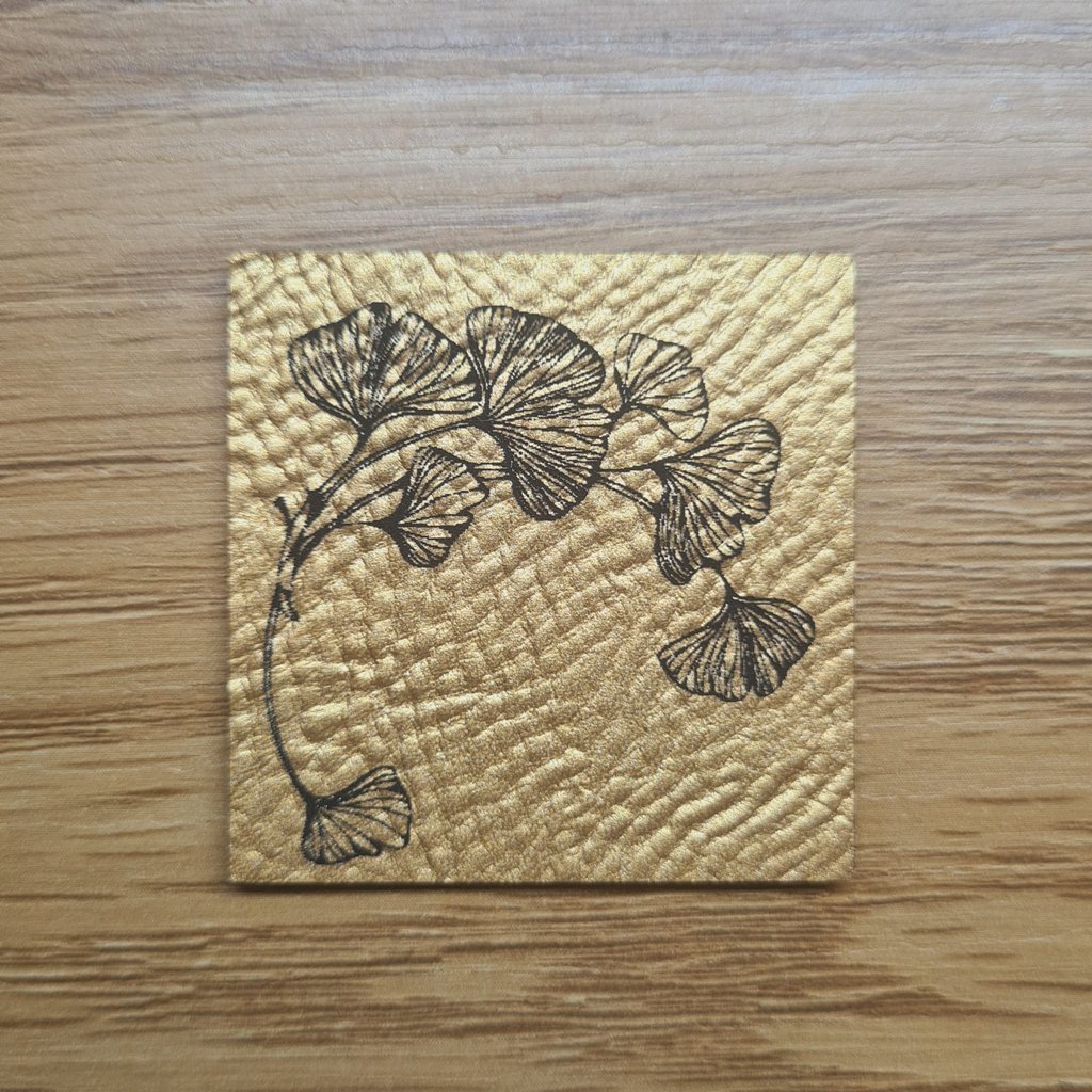 Quadratisches goldenes Kunstleder-Label mit einem filigranen Ginkgo-Blatt, ca. 4 x 4 cm, veganes Leder-Patch in Metallic-Optik, laser-graviert bei Schnuckidu