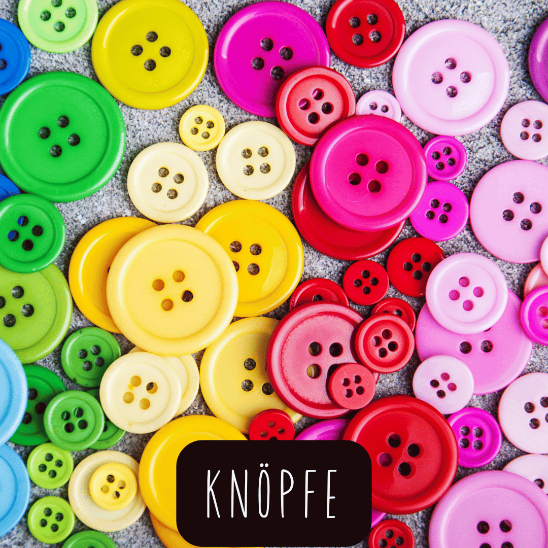 Bunte Knöpfe in verschiedenen Größen und mit vier Löchern auf grauem Untergrund mit dem Schriftzug 'KNÖPFE'