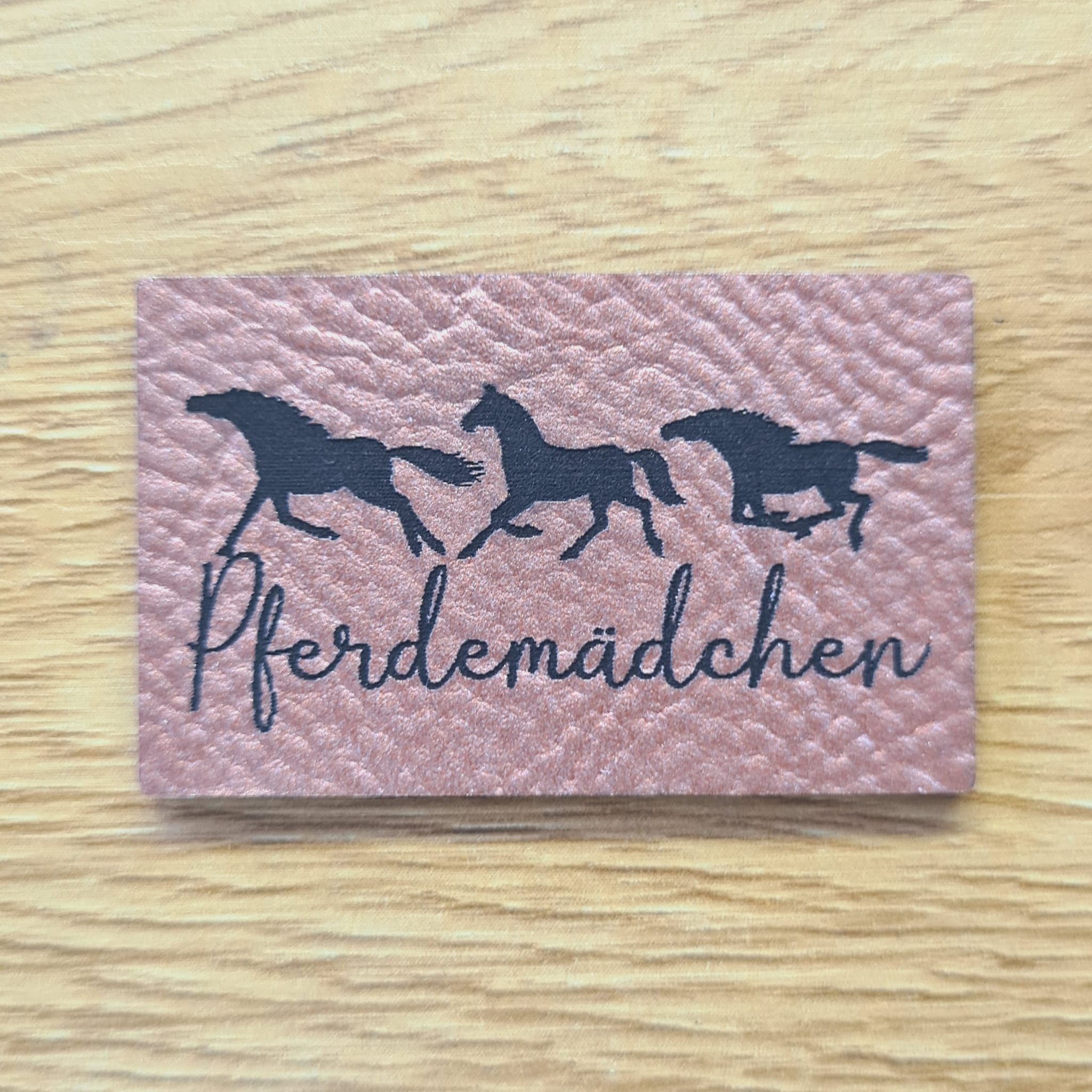 Rechteckiges rosegoldenes Kunstleder-Label mit dem gravierten Schriftzug „Pferdemädchen“, 4,4 x 2,7 cm, veganes, dickeres Nählabel für Reitbekleidung und Taschen, laser-graviert bei Schnuckidu.