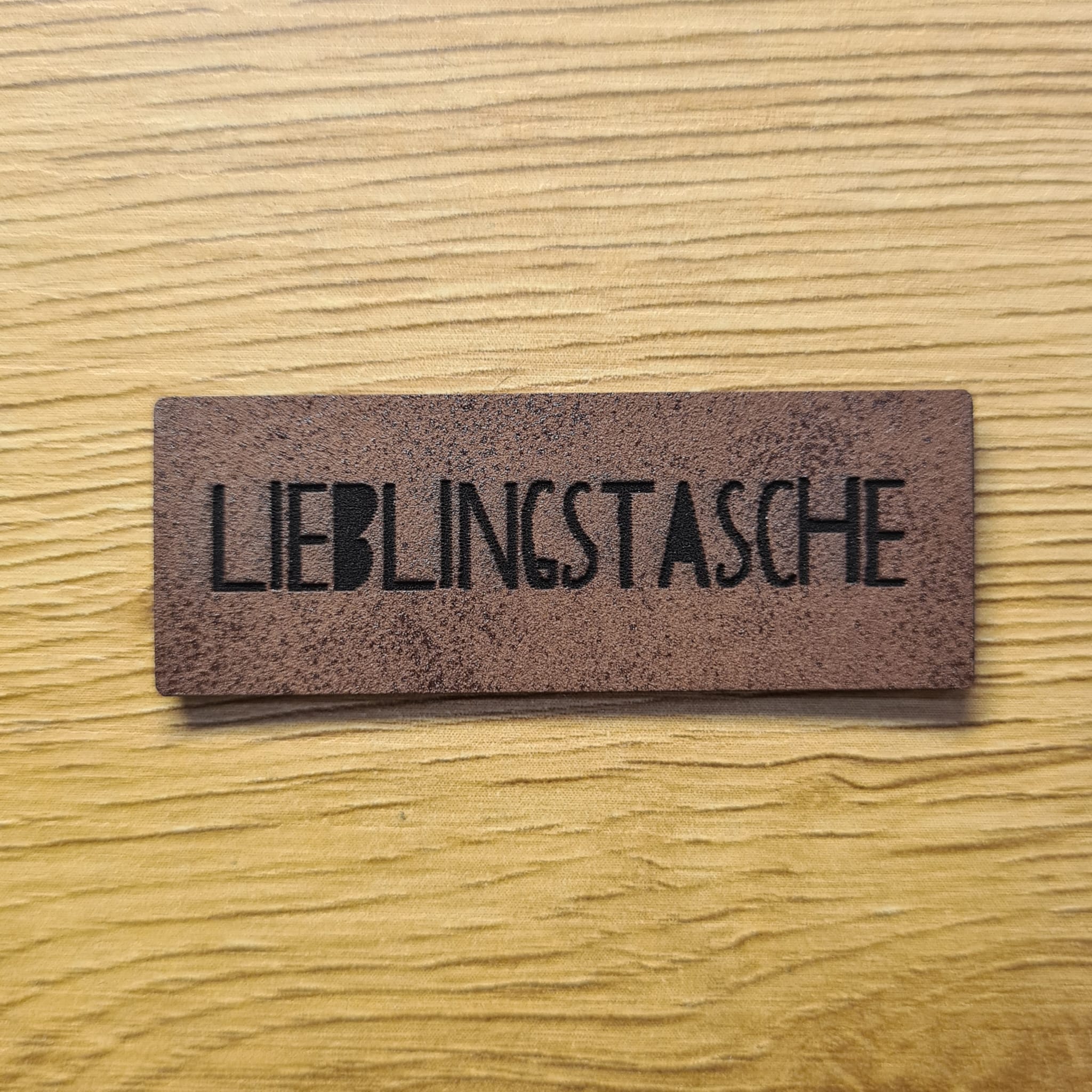 Schmales dunkelbraunes Kunstleder-Label mit der Aufschrift „Lieblingstasche“, ca. 5 x 1,8 cm, veganes Leder-Patch in Echtleder-Optik, laser-graviert bei Schnuckidu