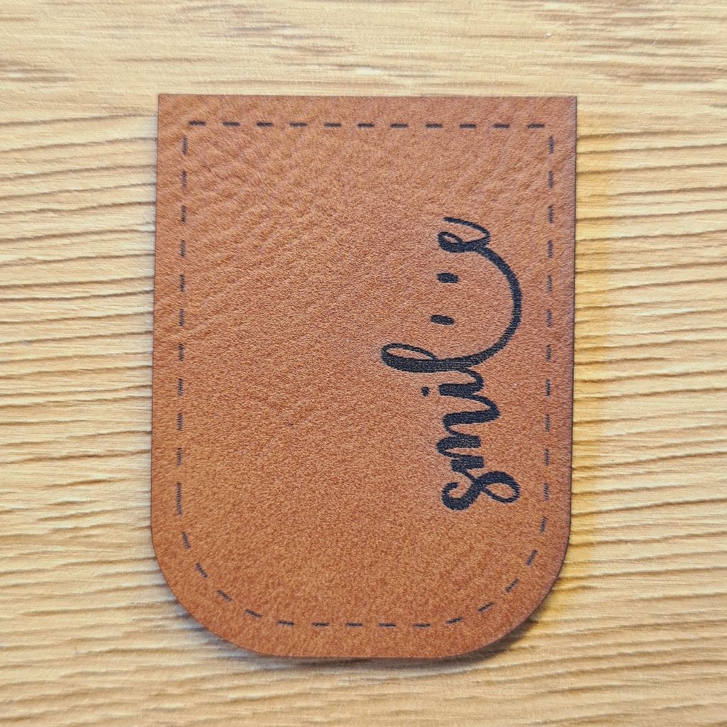 Braunes Kunstleder-Kordelende „smile“, U-förmig zum Aufnähen, handgeschriebener Look für Hoodies und Taschen, vegan, laser-graviert bei Schnuckidu