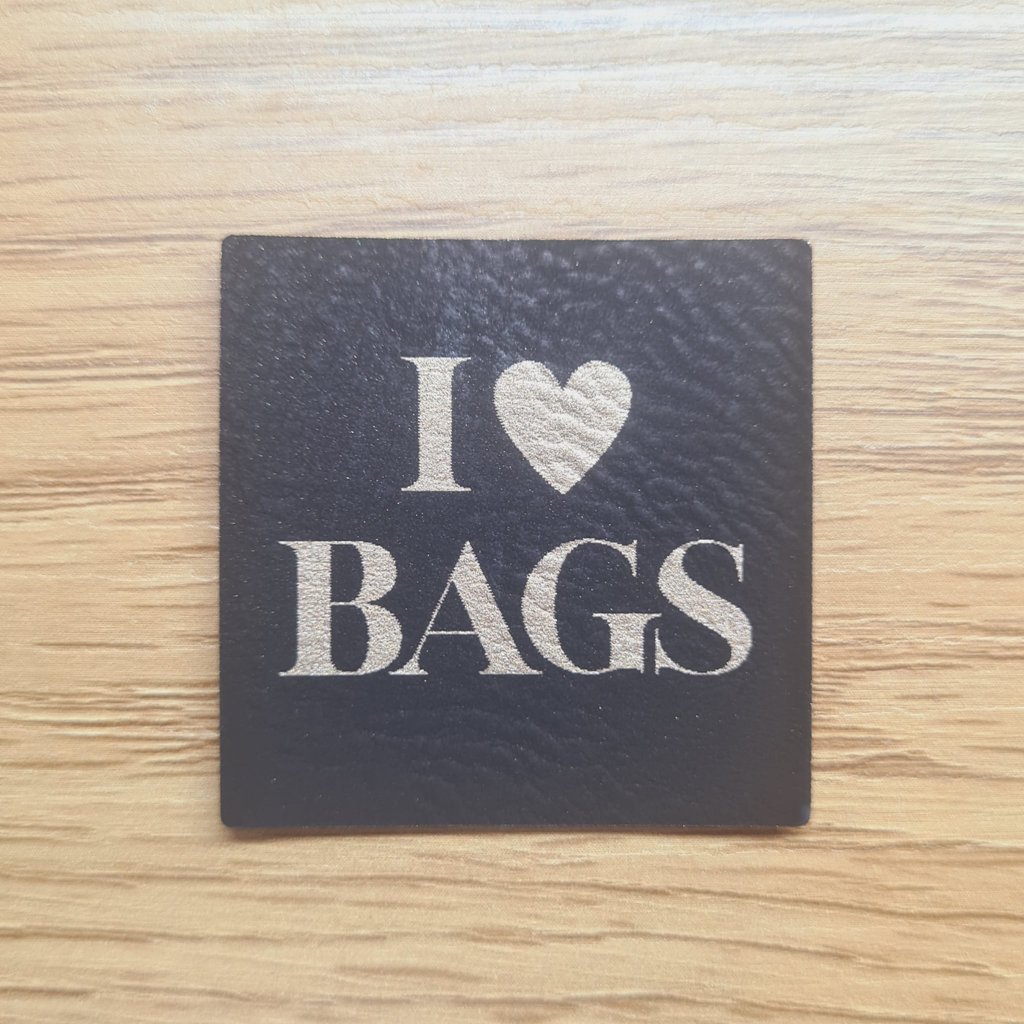 Quadratisches schwarzes Kunstleder-Label mit goldener Schrift „I LOVE BAGS“, ca. 4 x 4 cm, veganes Leder-Patch mit Herz-Symbol, laser-graviert bei Schnuckidu