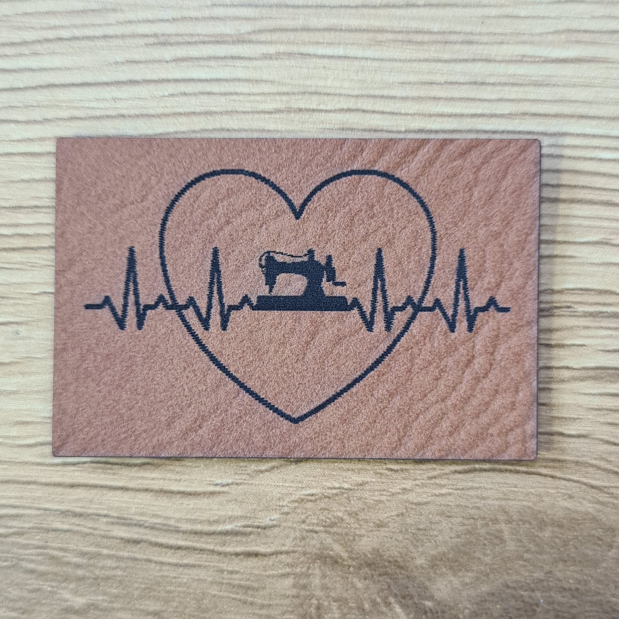 „Herzfrequenz mit Nähmaschine und Herz“ Nählabel 4×2,6cm – vegan, handmade, Schnuckidu® Kunstleder Braun