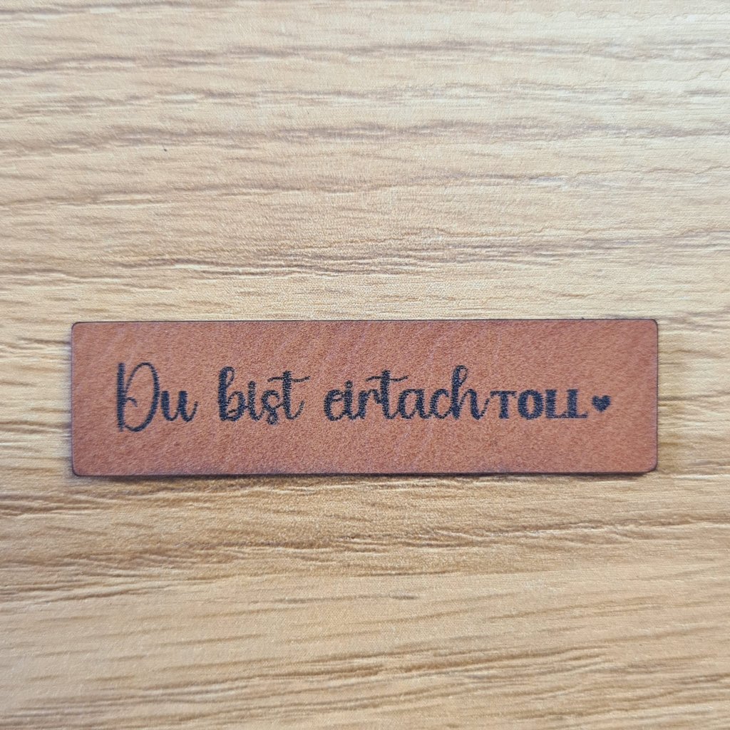 Schmales braunes Kunstleder-Label mit dem Spruch „Du bist einfach toll“, ca. 5 x 1,2 cm, veganes Leder-Patch für schmale Säume und Bündchen, laser-graviert bei Schnuckidu
