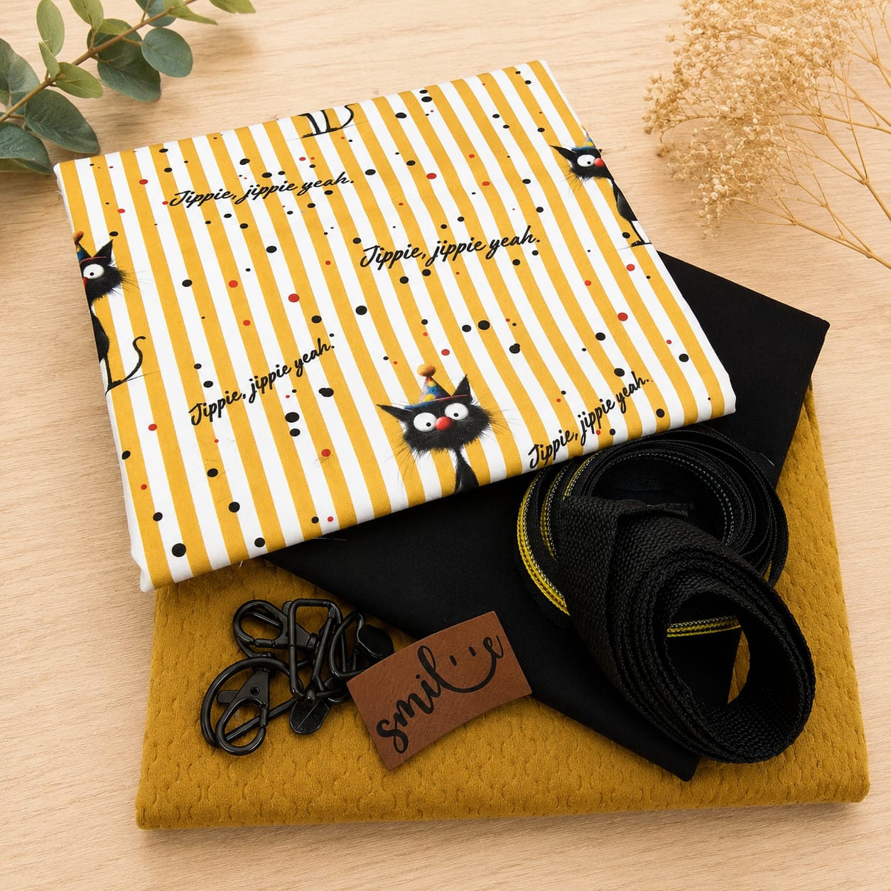 Schnuckidu Taschen-Stoffpaket Jippie Yeah Cat mit Katzen-Webware, schwarzem Kombistoff, senfgelbem Samt, schwarzem Gurtband, Reißverschluss, schwarzen Karabinern und braunem Kunstleder-Label "smile".