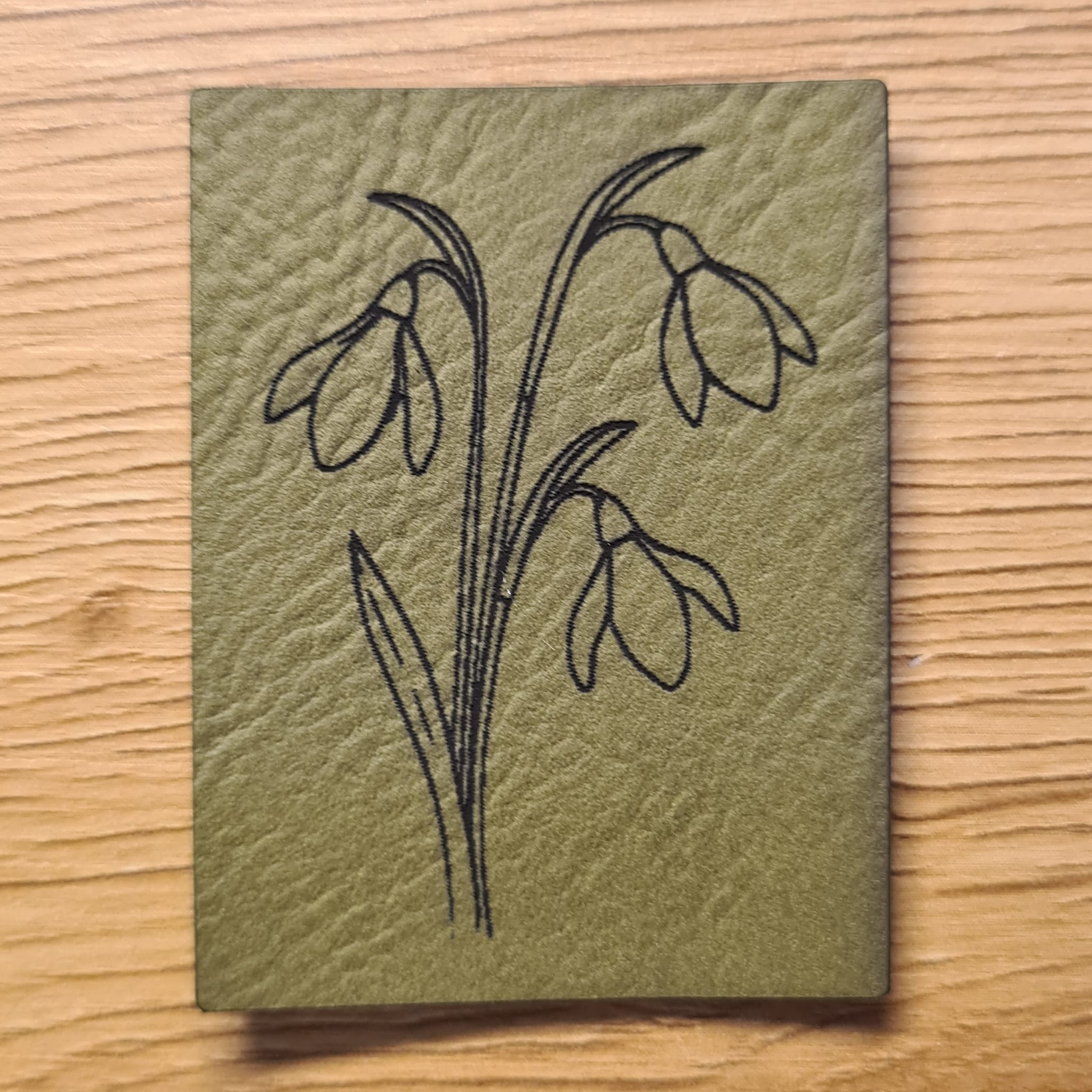 Kunstleder-Label „Schneeglöckchen“, 5 x 3,7 cm, florales Design für Nähprojekte, vegan, laser-graviert bei Schnuckidu, in Khaki.