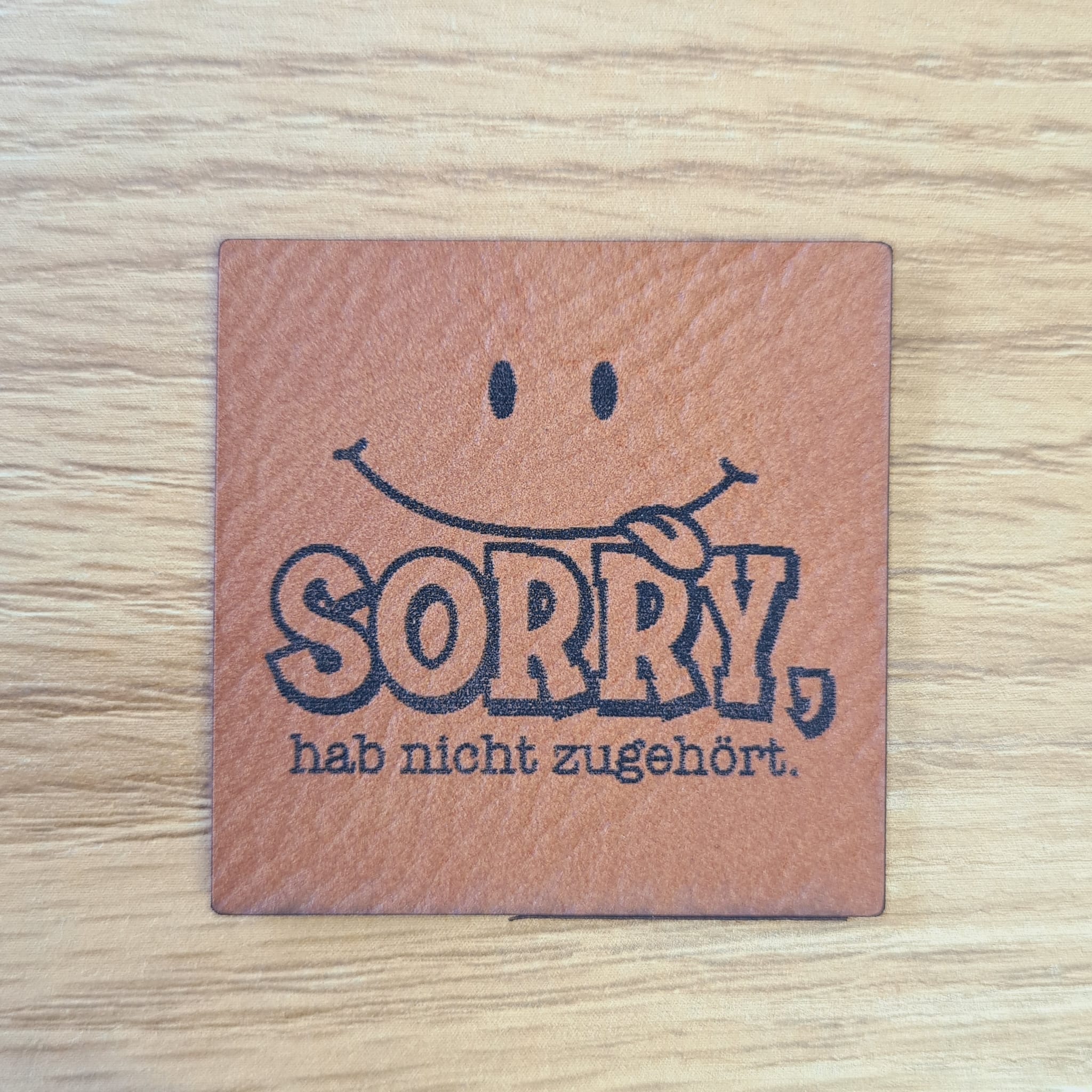 Quadratisches braunes Kunstleder-Label mit dem Spruch „Sorry, hab nicht zugehört“, ca. 4 x 4 cm, veganes Leder-Patch für Humor-Liebhaber, laser-graviert bei Schnuckidu