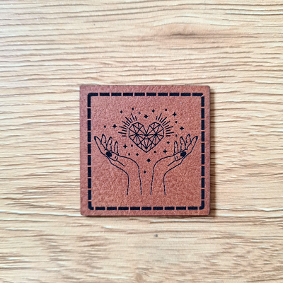 „Hände mit Herz“ Nählabel 4×4 cm – vegan, handmade, Schnuckidu® Kunstleder Braun/Schwarz