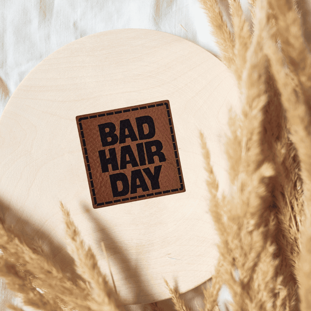 Quadratisches braunes Kunstleder-Label mit dem Schriftzug „Bad Hair Day“, 4 x 4 cm, veganes Nählabel für Mützen und Stirnbänder, laser-graviert bei Schnuckidu.