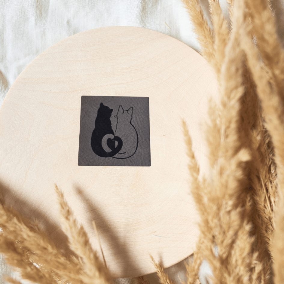Quadratisches graues Kunstleder-Label mit einem schmusenden Katzenpaar-Motiv, 4 x 4 cm, veganes Nählabel für Tierfreunde, laser-graviert bei Schnuckidu.