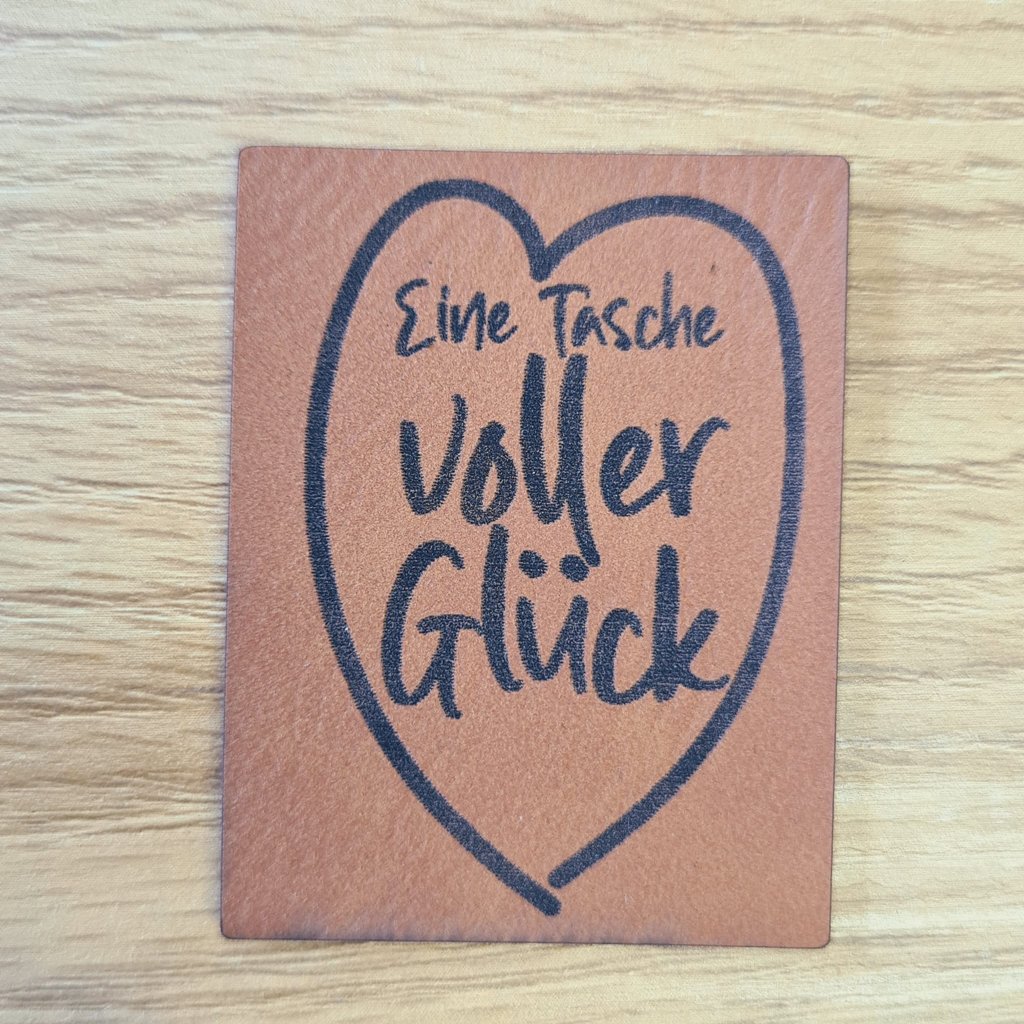 Hochformatiges braunes Kunstleder-Label mit dem Spruch „Tasche voller Glück“, ca. 3,8 x 5 cm, veganes Leder-Patch für selbstgenähte Taschen, laser-graviert bei Schnuckidu