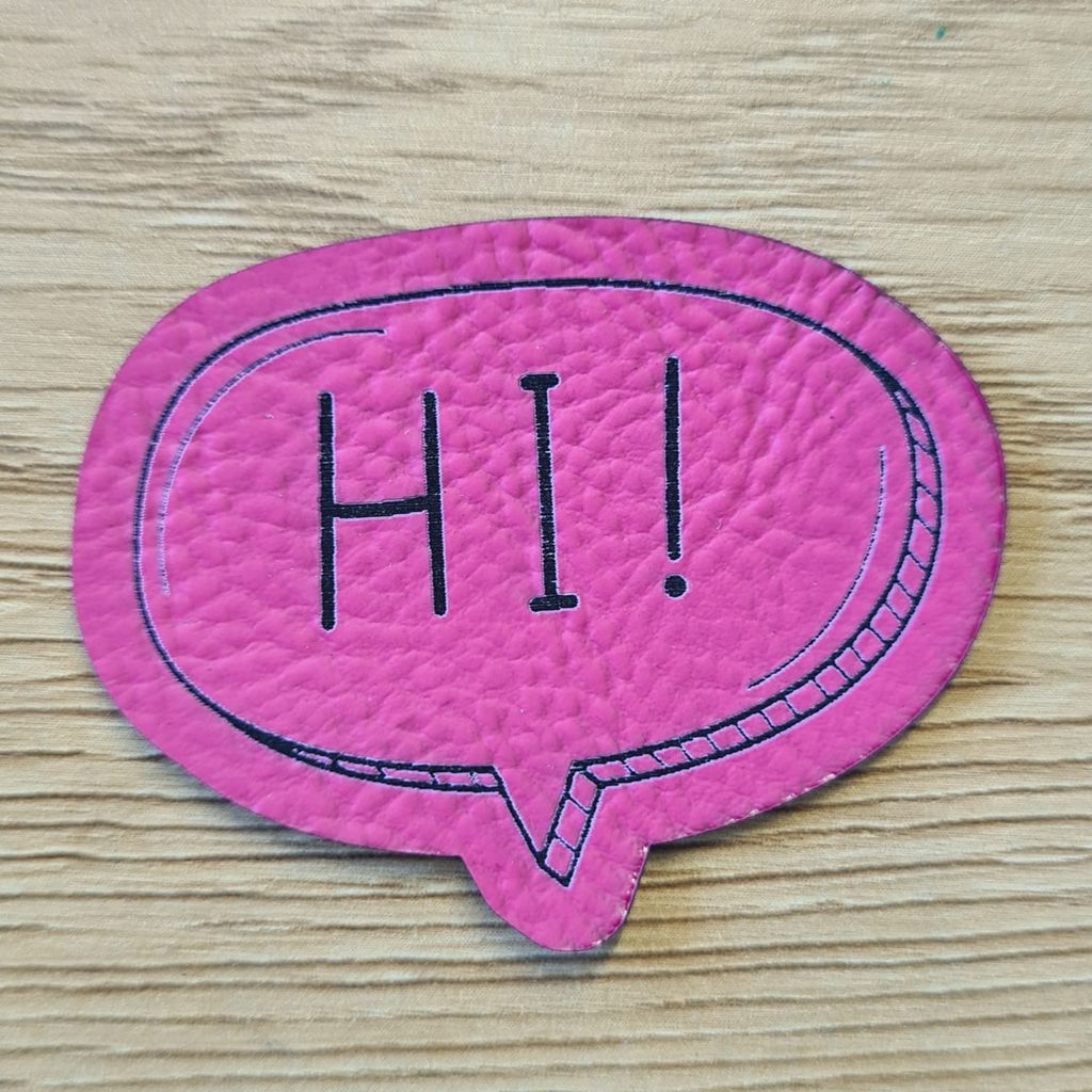 Pinkes Kunstleder-Nählabel in Freiform als Sprechblase mit dem Schriftzug „HI“, 5 x 3,9 cm, veganes Patch für fröhliche Kinderkleidung und Accessoires, laser-graviert bei Schnuckidu.