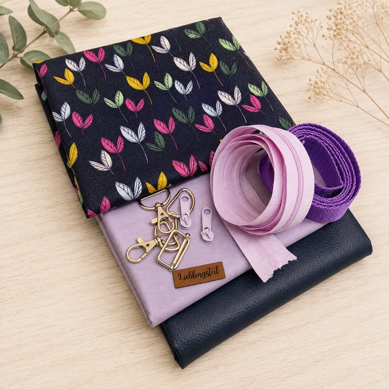 Schnuckidu Stoffpaket Taschenpaket Dancing Leaves mit gemustertem Canvas, Uni Webware in Flieder, dunkelblauem Kunstleder Rex, lila Gurtband, goldenem Zubehör und Kunstlederlabel Lieblingsteil.