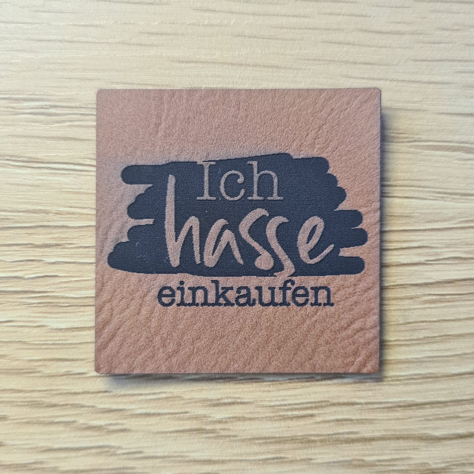 Schnuckidu Kunstleder Nählabel in Braun quadratisch mit Brush-Hintergrund und dem Spruch Ich hasse einkaufen.
